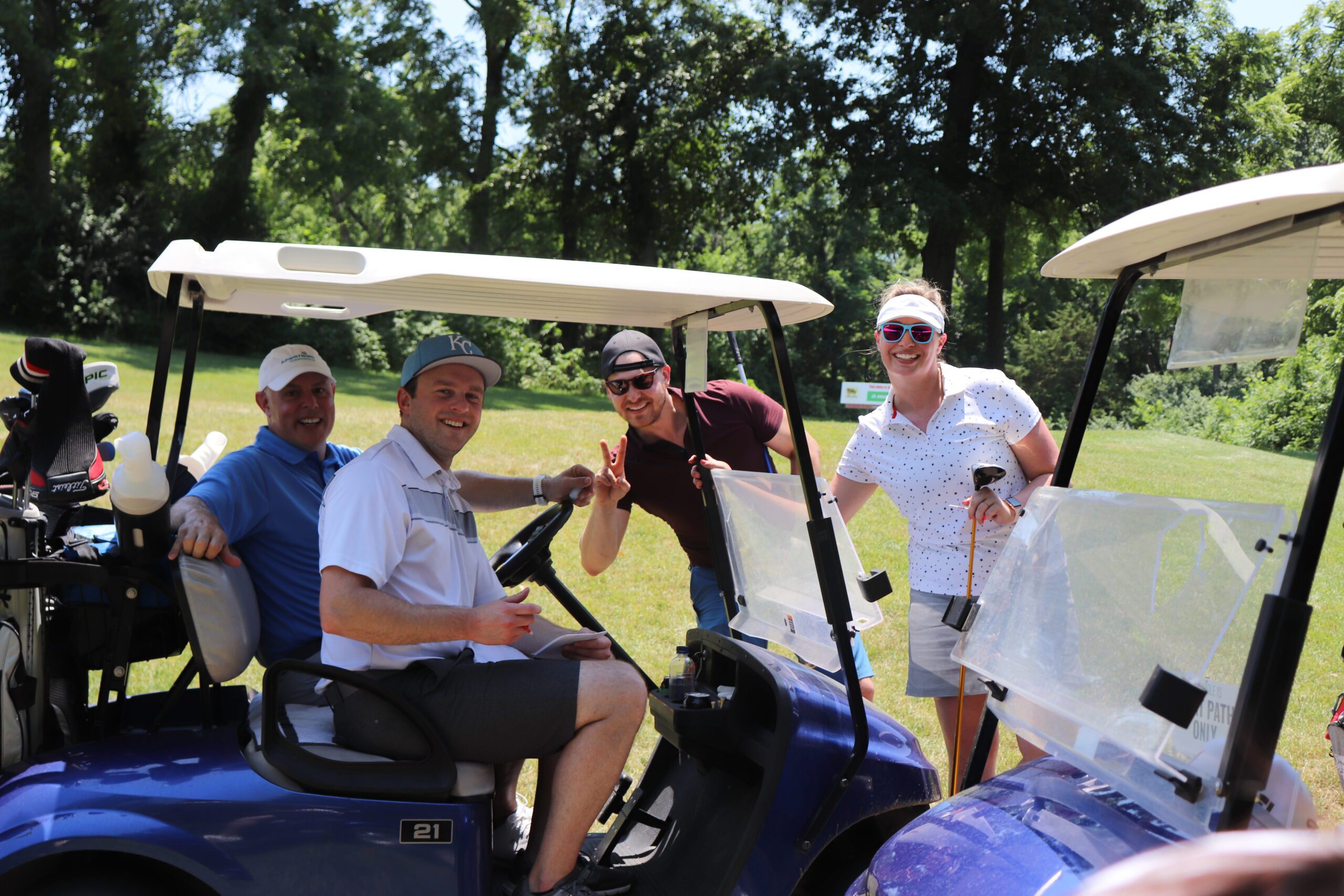Group of men posing next to a golf cart