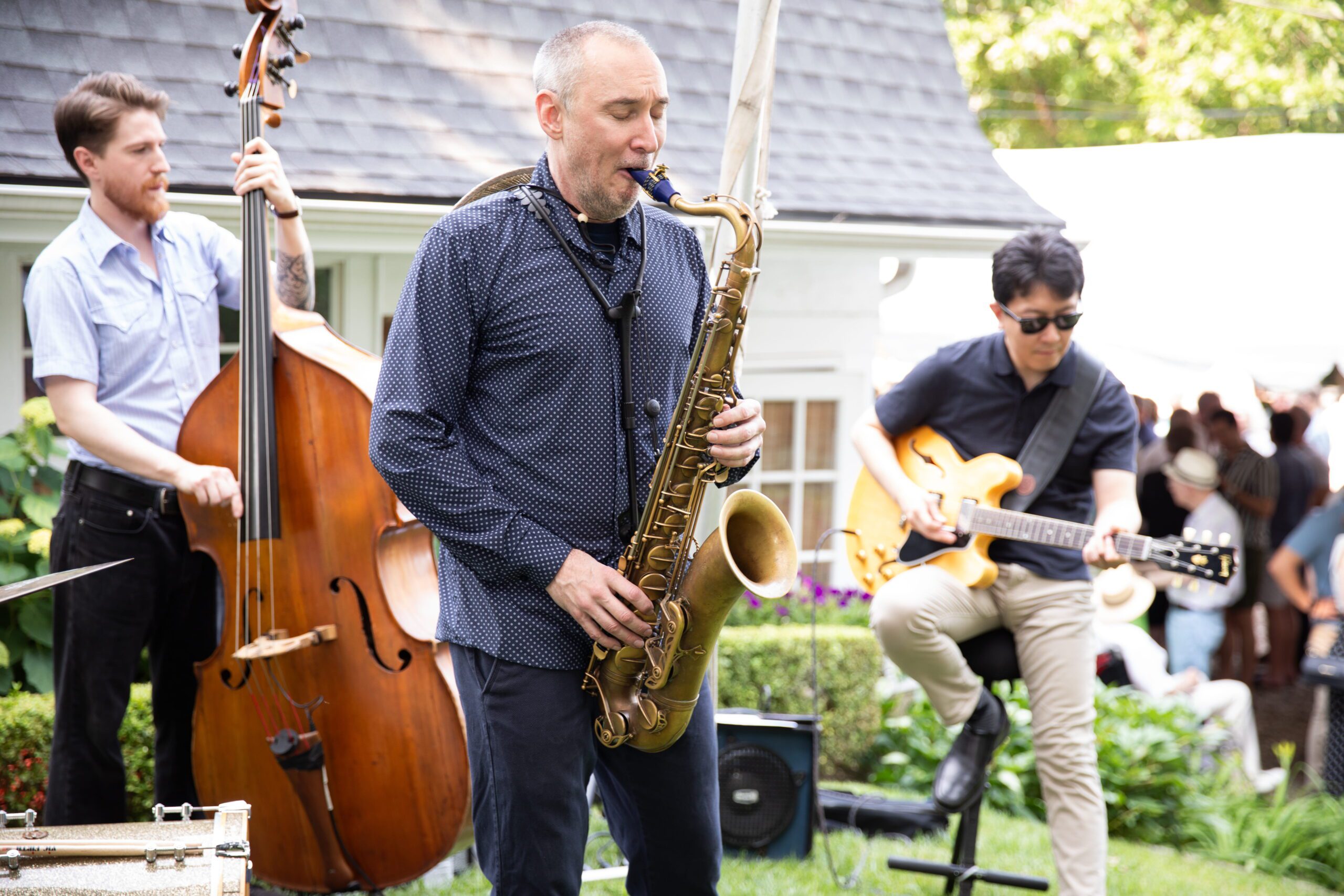 Man playing the saxophone with a band behind him