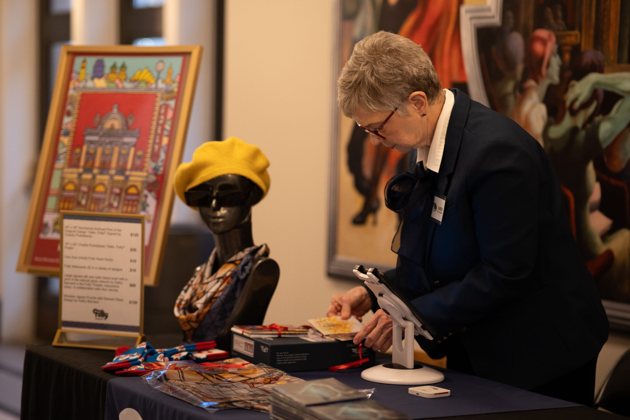 A person setting up a table to display different objects